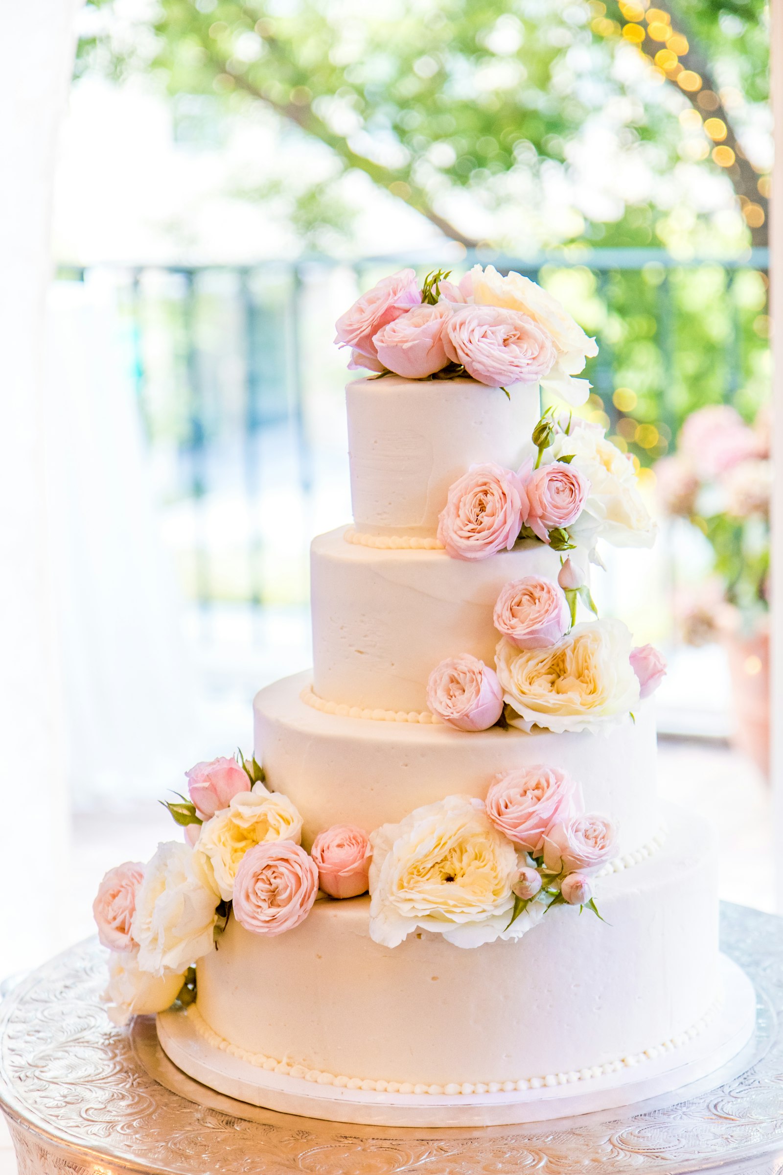 Elegant tiered custom cake with fresh roses